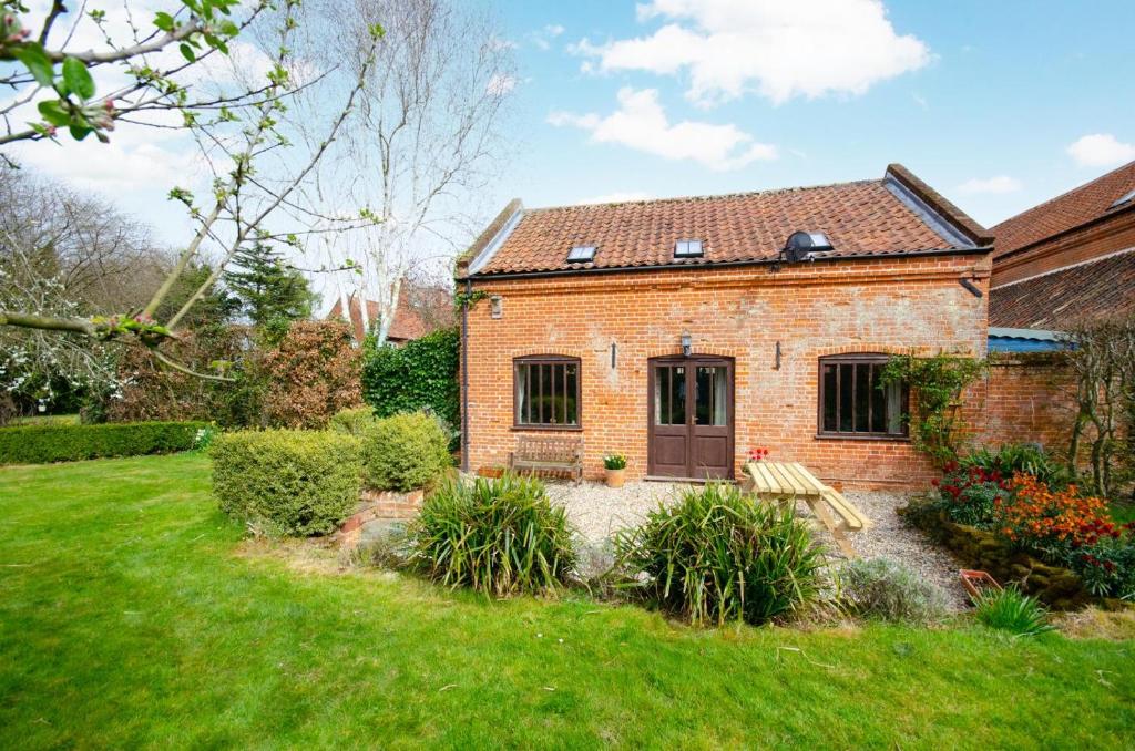 a brick house with a bench in a yard at 2 Bed in Erpingham oc-2278 in Erpingham