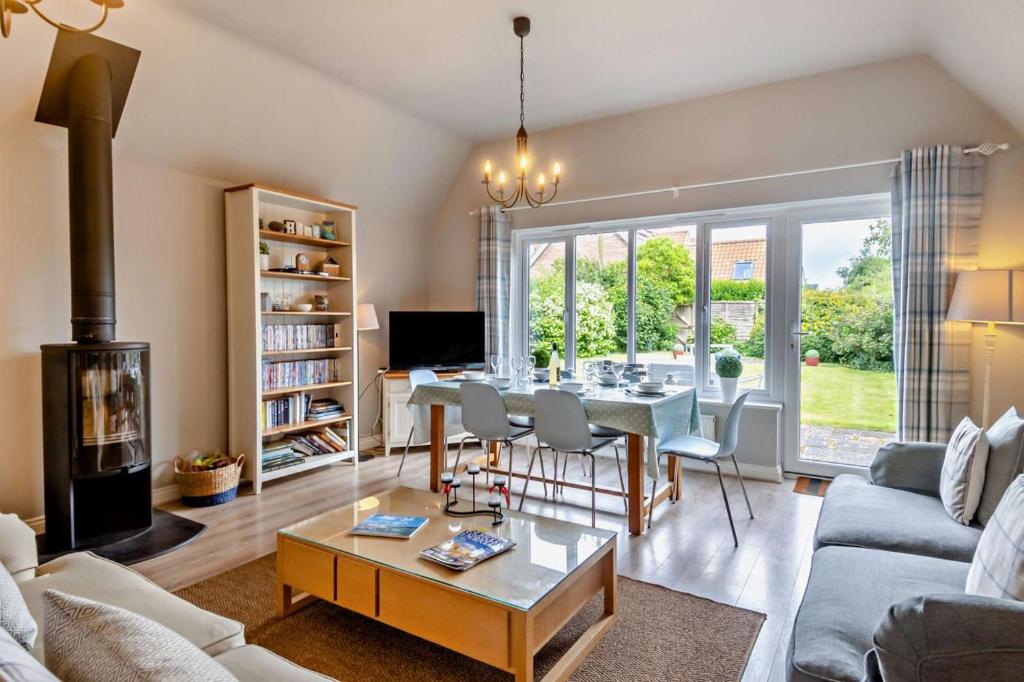 a living room with a table and a fireplace at 4 Bed in Southwold oc-hsumme in Reydon