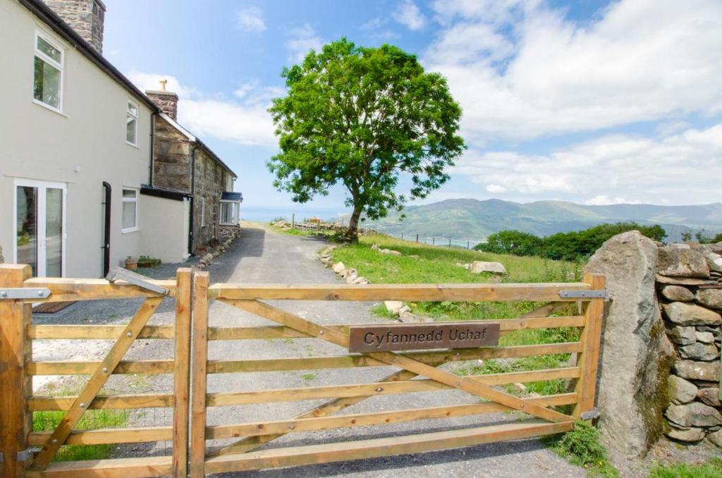 a wooden gate with a sign on it in front of a house at 6 Bed in Barmouth oc-bow245 in Fairbourne