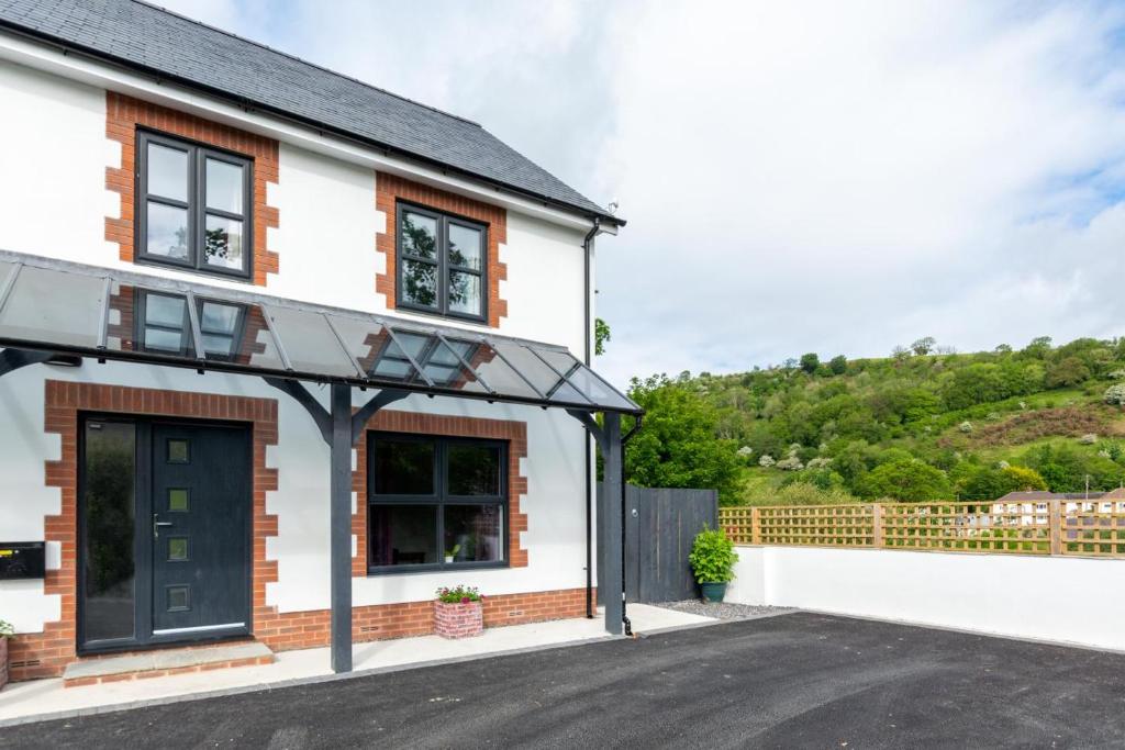 a white house with a black door and a driveway at 3 Bed in Llanfynydd oc-pw9215 in Llanfynydd