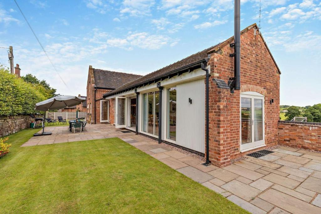 an exterior view of a brick house with a yard at 4 Bed in Slindon oc-t29883 in Eccleshall