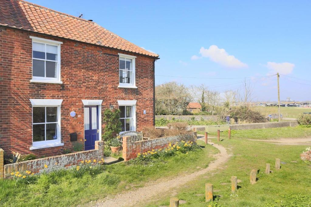 a brick house with a dirt road in front of it at 3 Bed in Walberswick oc-aaferr in Walberswick