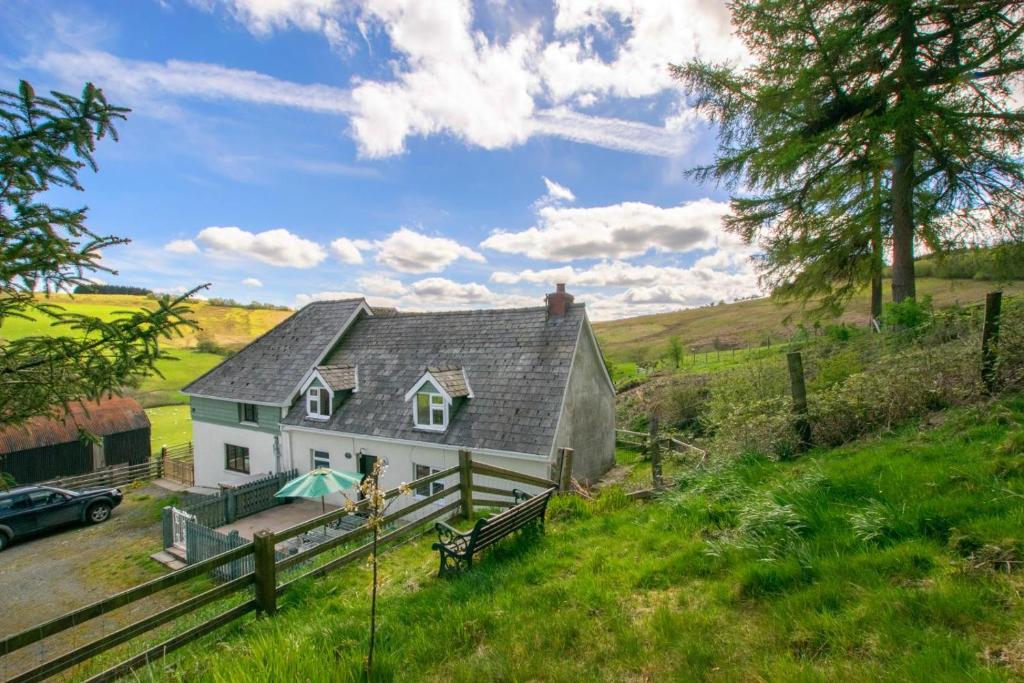 a house on a hill with a car parked next to it at 3 Bed in Builth Wells oc-wal257 in Maesmynis