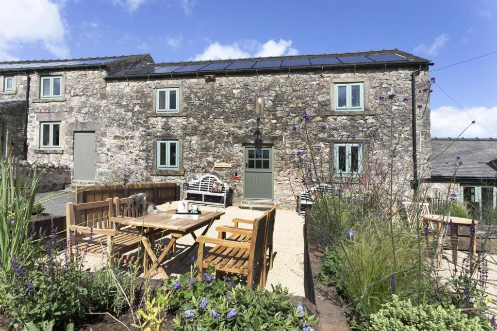 a stone cottage with a wooden table and chairs at 2 Bed in Brassington oc-dcgol in Brassington
