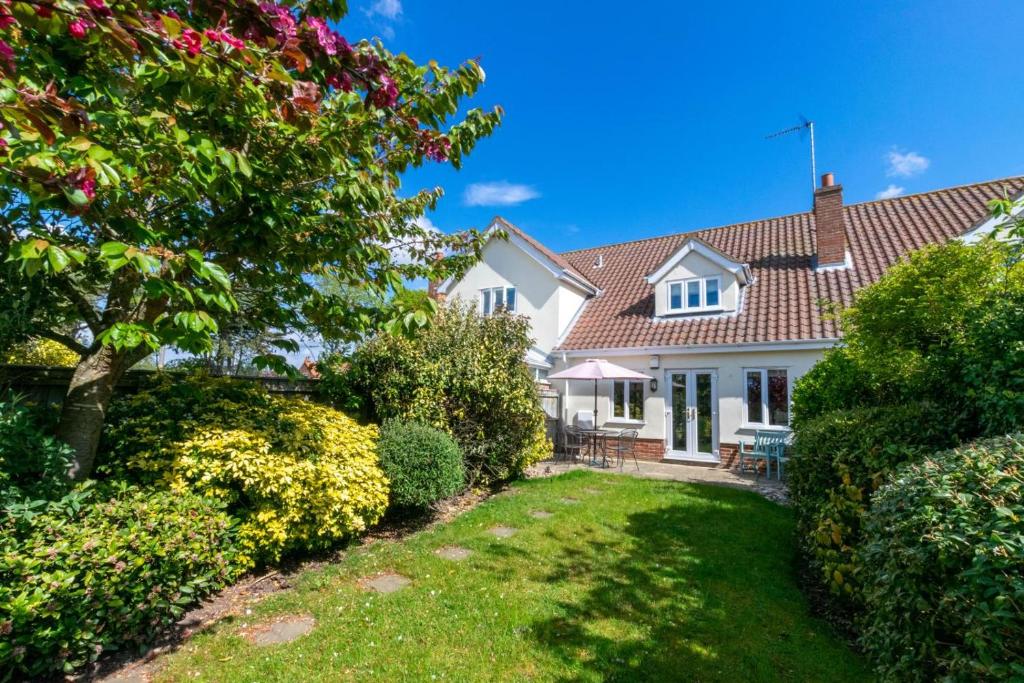 a white house with a yard with bushes at 3 Bed in Southwold oc-fie2 in Reydon