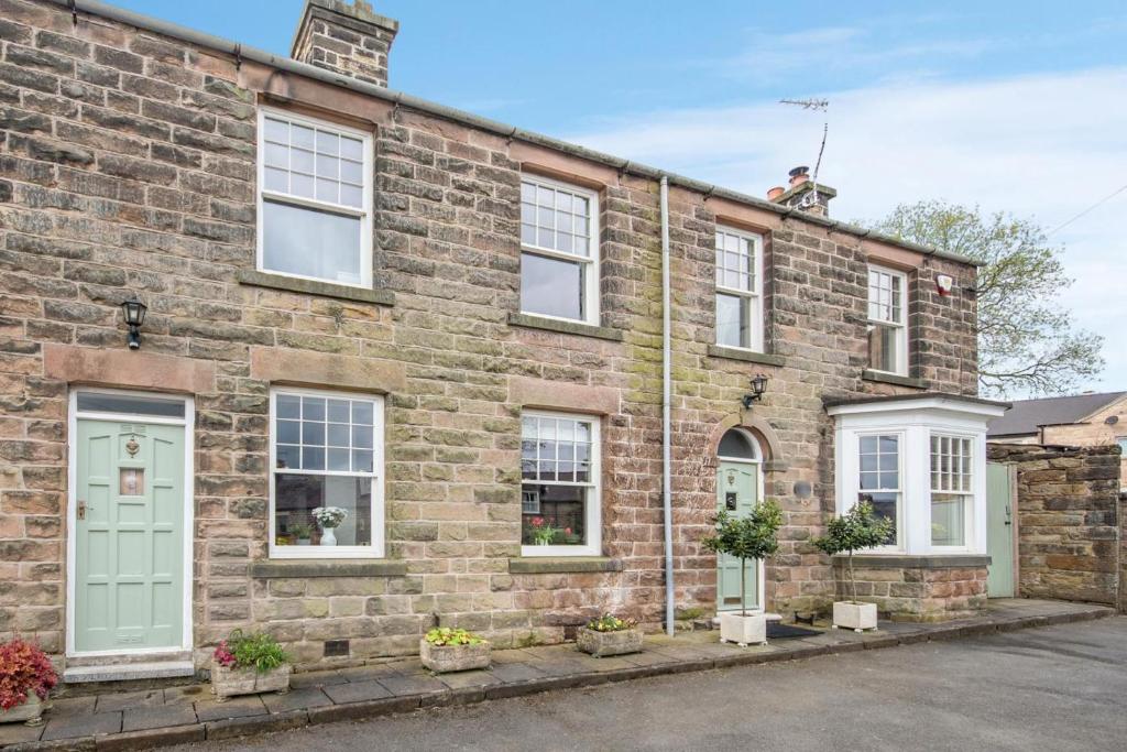 a brick house with a green door and windows at 3 Bed in Crich oc-dcivyd in Crich