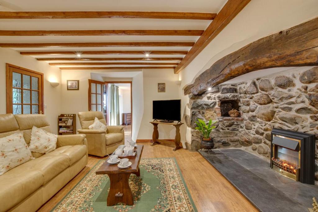 a large living room with a stone fireplace at 2 Bed in Barmouth oc-wah699 in Talybont