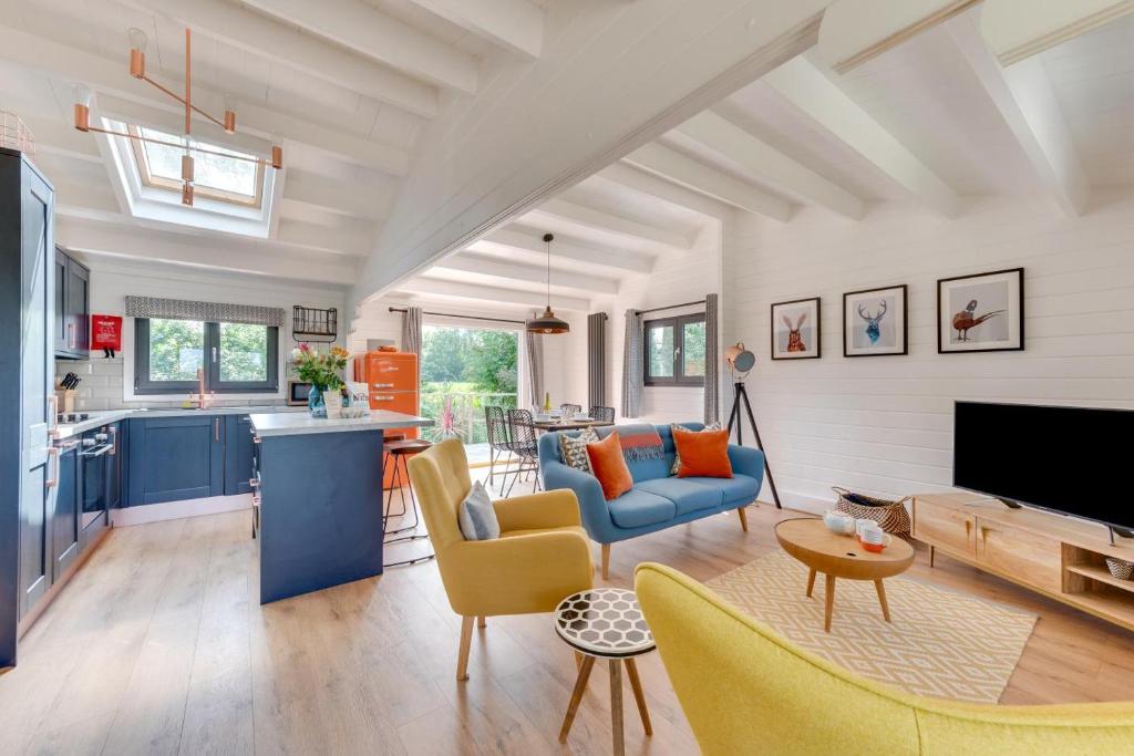 a living room with a blue couch and yellow chairs at 2 Bed in Stradbroke oc-wopl in Stradbroke