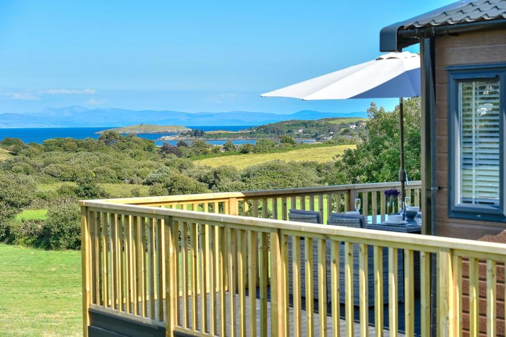 a wooden deck with a view of the ocean at 2 Bed in Abersoch oc-atacam in Abersoch