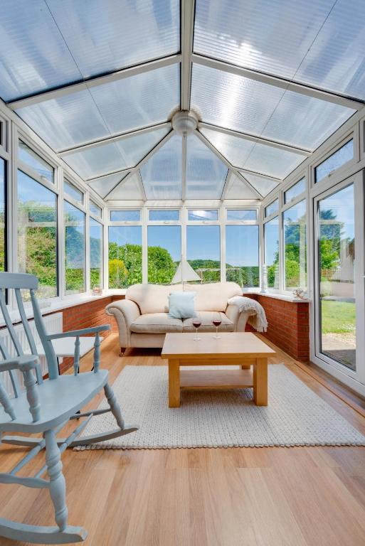 a conservatory with a couch and a table and windows at 3 Bed in Trimingham oc-2290 in Trimingham