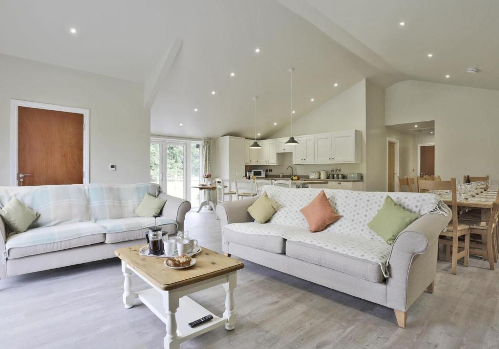 a living room with two couches and a table at 10 Bed in Barsham oc-rrest in Beccles