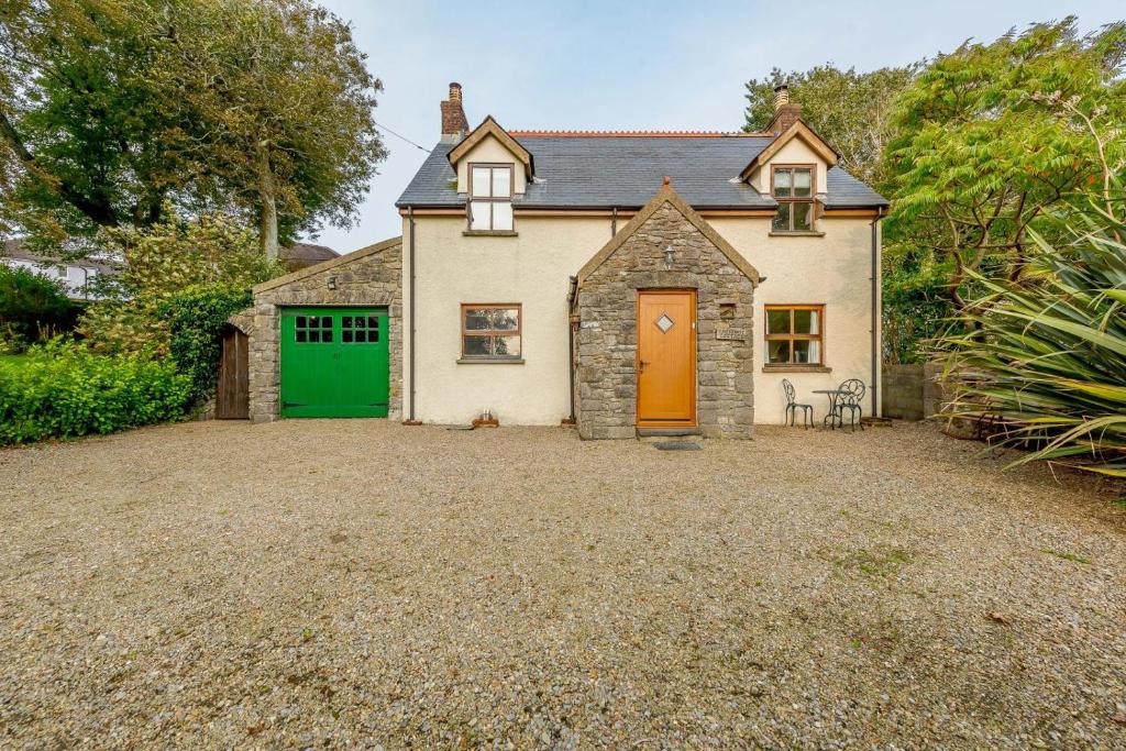 a house with a green door and a gravel driveway at 3 Bed in Manorbier oc-pw270a in Manorbier