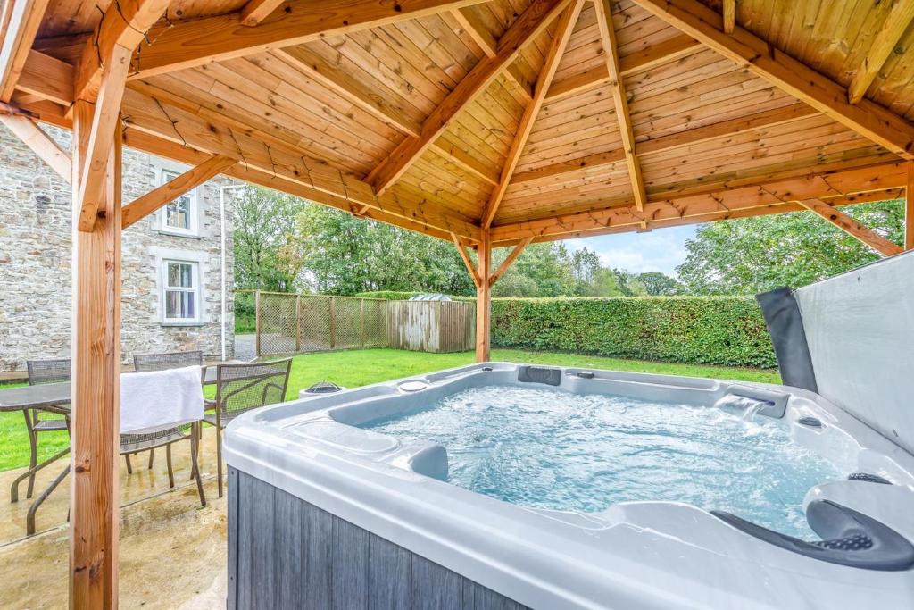 a hot tub under a wooden roof in a yard at 2 Bed in Llandysul oc-was280 in Rhyd Lewis
