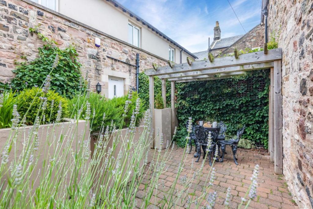 a patio with a table and chairs in front of a building at 2 Bed in Bamburgh oc-gd0462 in Bamburgh