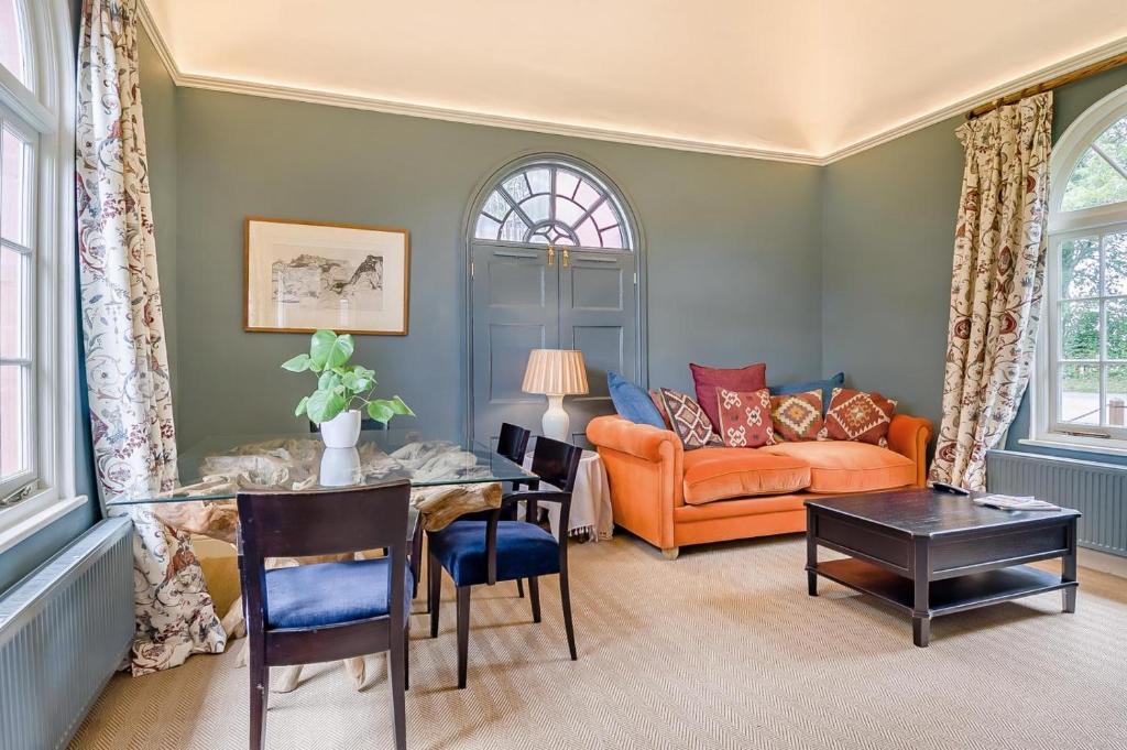 a living room with an orange couch and a table at 1 Bed in Wymondham oc-e32664 in Wymondham