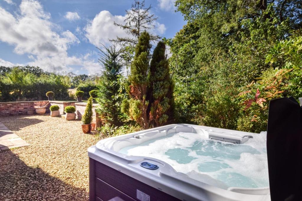 a jacuzzi tub in a yard with trees at 3 Bed in Thelwall oc-c29954 in Warrington