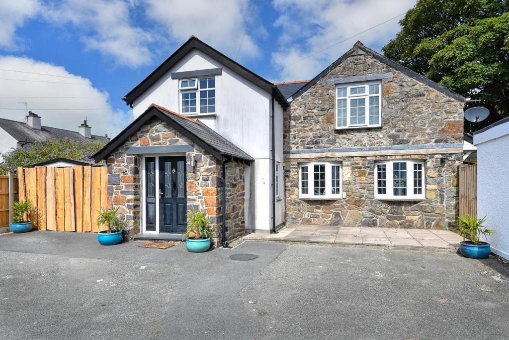 a stone house with potted plants in a driveway at 4 Bed in Abersoch oc-egrypo in Abersoch