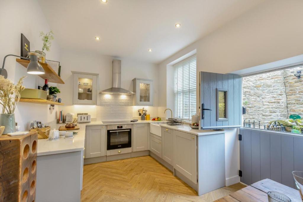 a kitchen with white cabinets and a large window at 3 Bed in Carperby oc-ds058 in Carperby