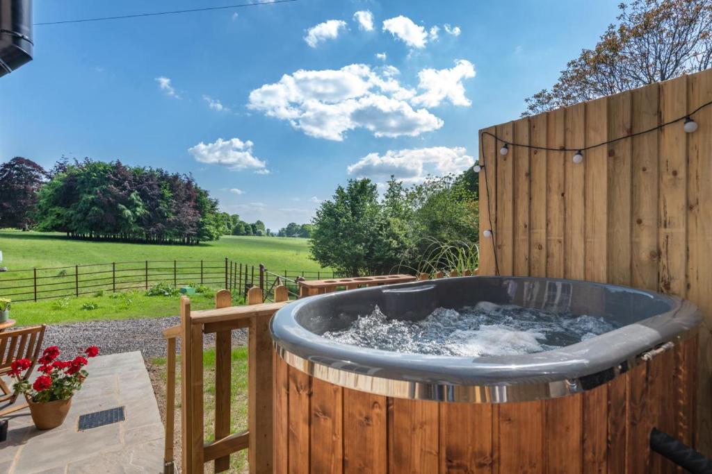 a hot tub in a garden with a wooden fence at 1 Bed in Tollard Royal oc-t29453 in Tollard Royal
