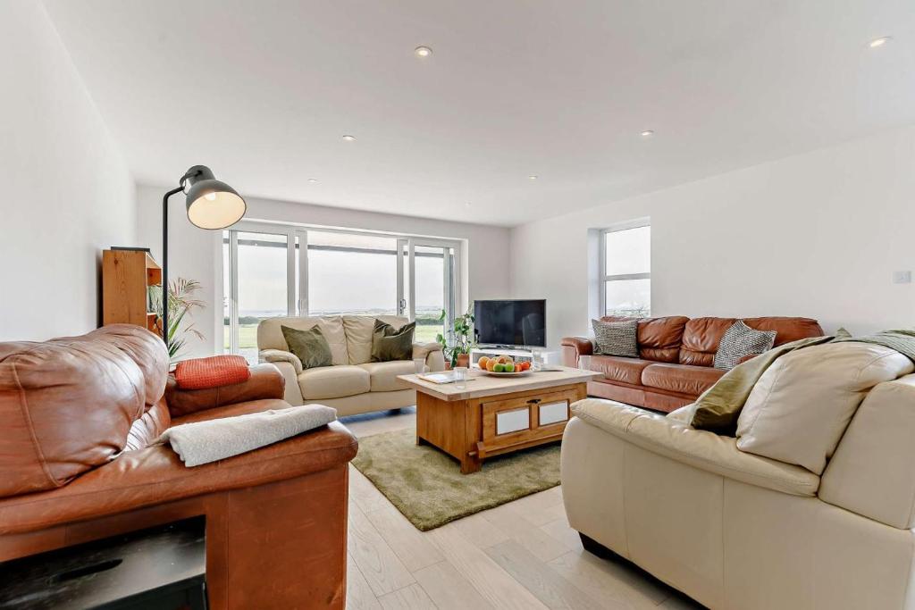 a living room with two couches and a table at 5 Bed in St. Merryn oc-t27899 in Saint Merryn