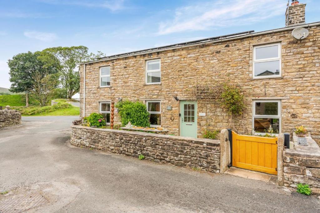 a brick house with a green door and a fence at 3 Bed in Appersett oc-ds944 in Appersett