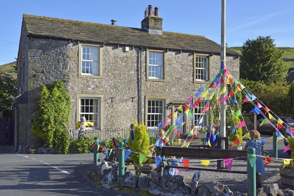 a stone house with a kite in front of it at 5 Bed in Kettlewell oc-ds257 in Kettlewell