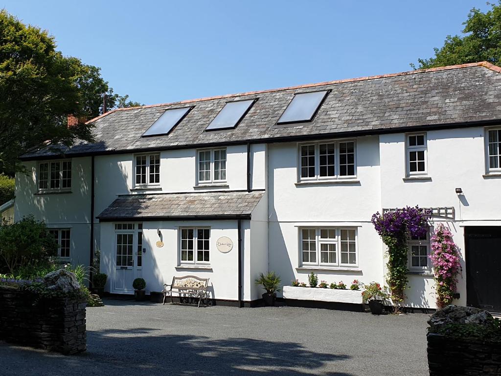 a white house with solar panels on the roof at Orchard Lodge in Boscastle