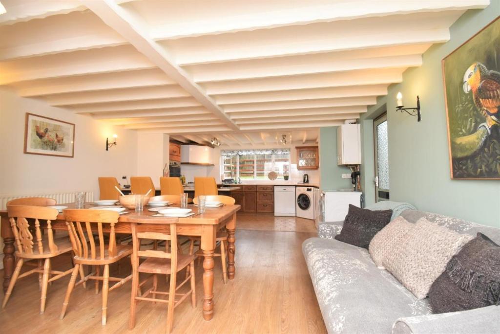a dining room and living room with a table and a couch at 4 Bed in Seaton oc-s27403 in Seaton