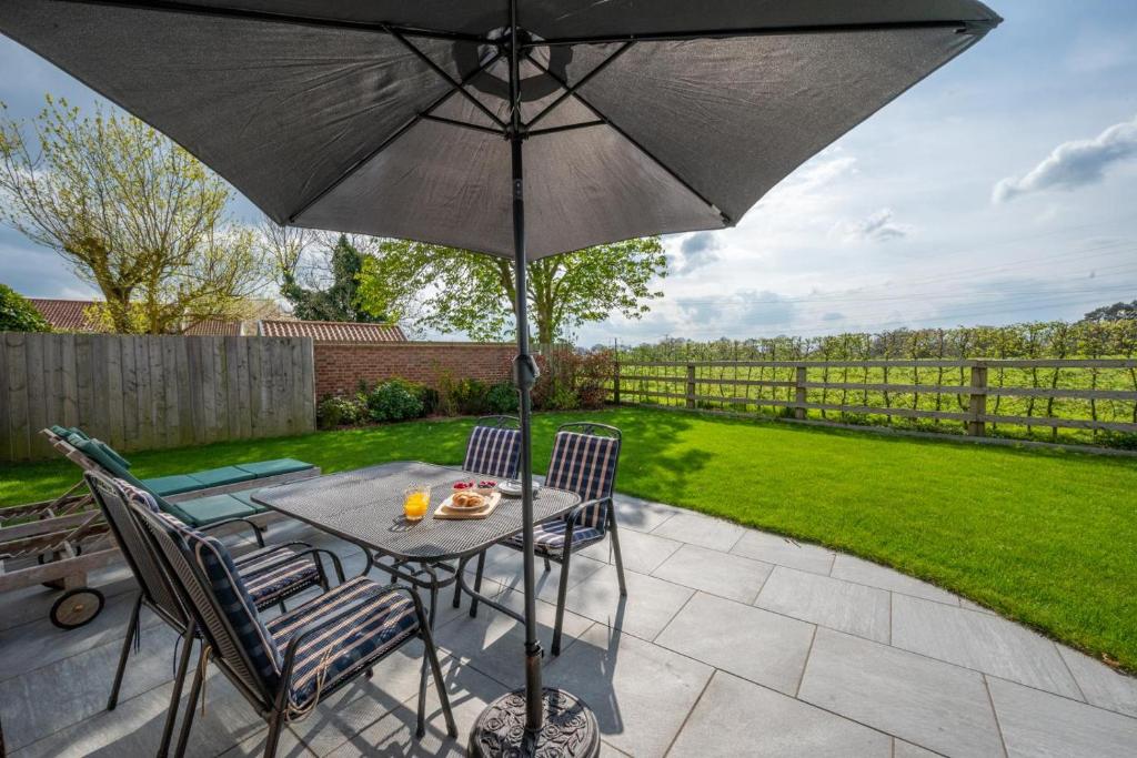 a table and chairs with an umbrella on a patio at 1 Bed in Booton oc-2266 in Cawston