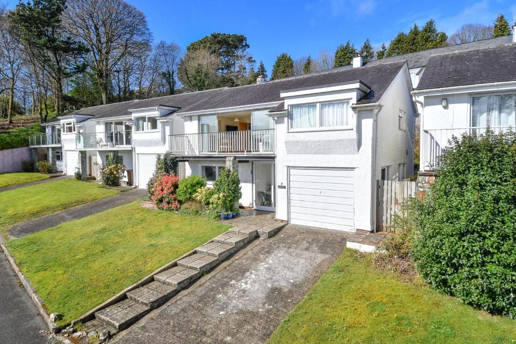a large white house with a garage at 3 Bed in Llanbedrog oc-gerddi in Llanbedrog