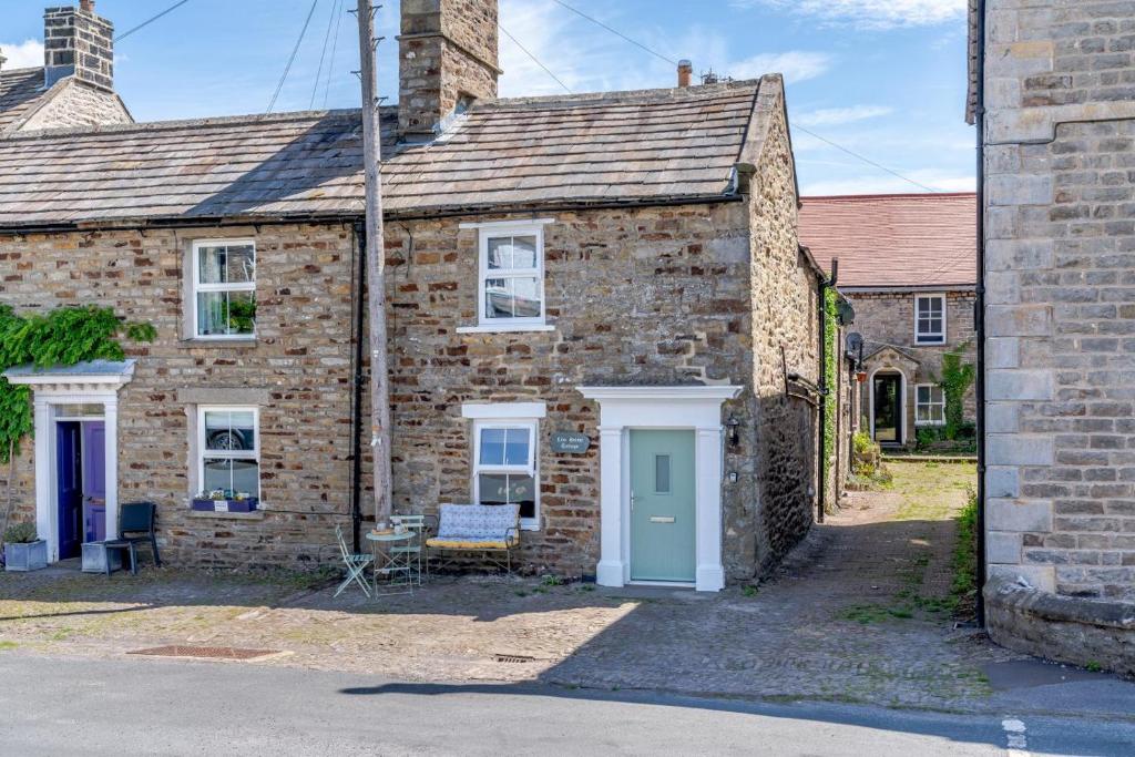 an old brick house with a blue door at 3 Bed in Reeth oc-l32438 in Reeth