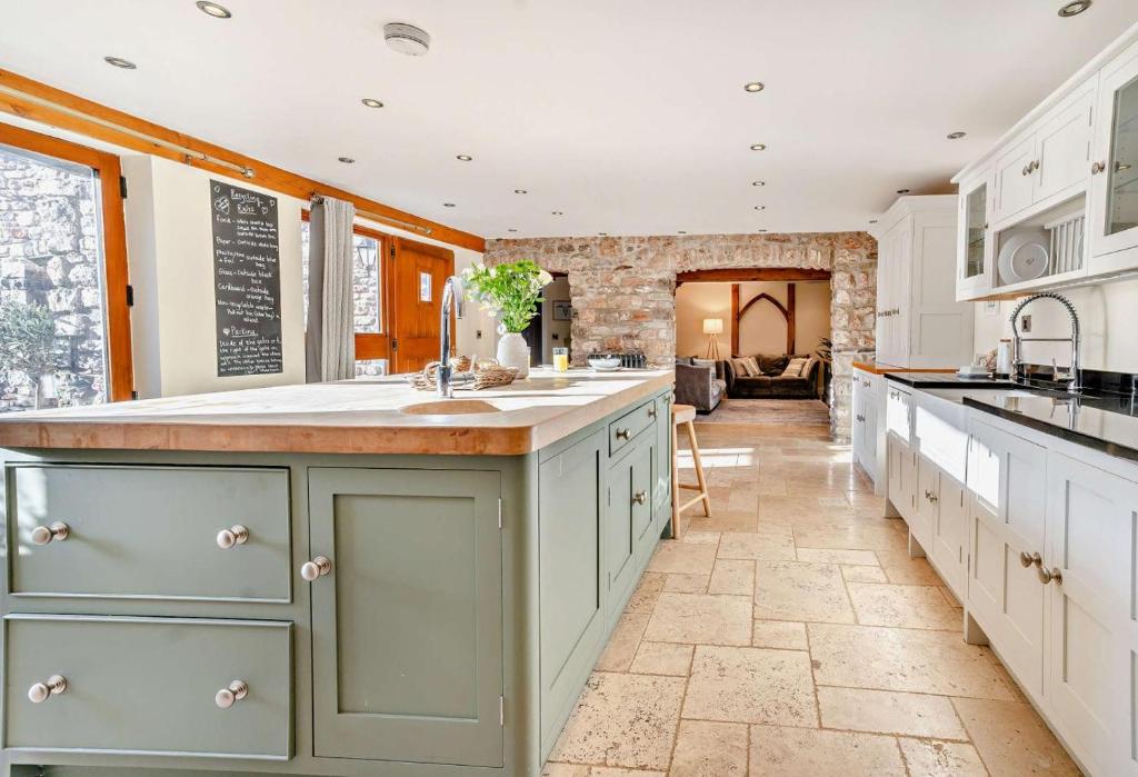 a large kitchen with white cabinets and a large island at 4 Bed in Nottage oc-t28401 in Nottage