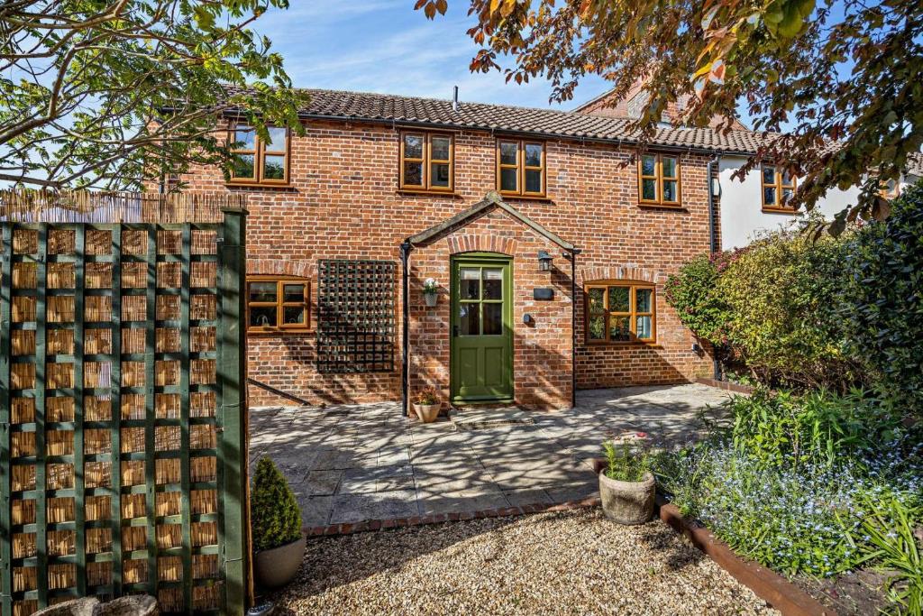 a brick house with a green door and a fence at 2 Bed in Dersingham oc-b27417 in Dersingham