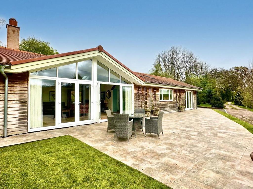 a patio with glass doors and a table and chairs at 2 Bed in Witheridge oc-b29206 in Witheridge