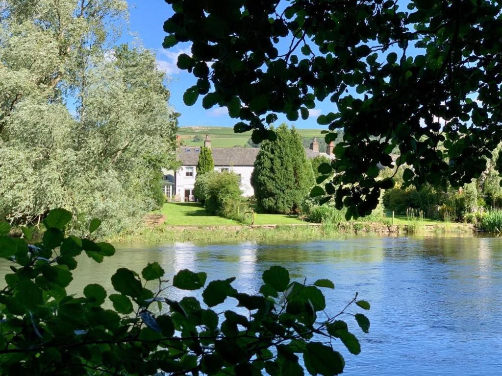a view of a river with a house in the background at 2 Bed in Pooley Bridge oc-l31060 in Pooley Bridge