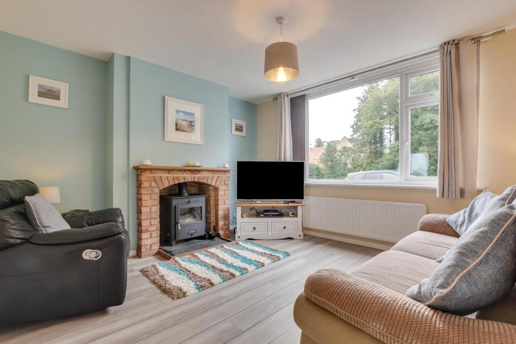 a living room with a fireplace and a tv at 3 Bed in Lucker oc-nb1938 in Lucker