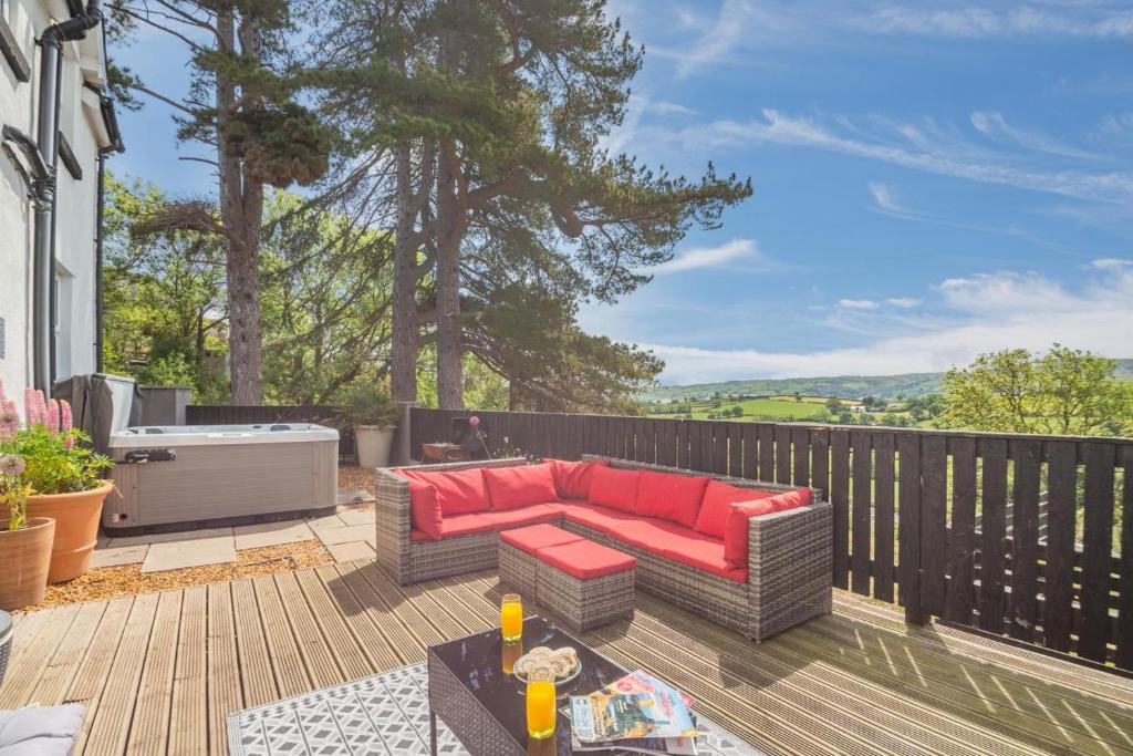 a patio with a red couch on a wooden deck at 3 Bed in Llysfaen oc-t32226 in Llysfaen