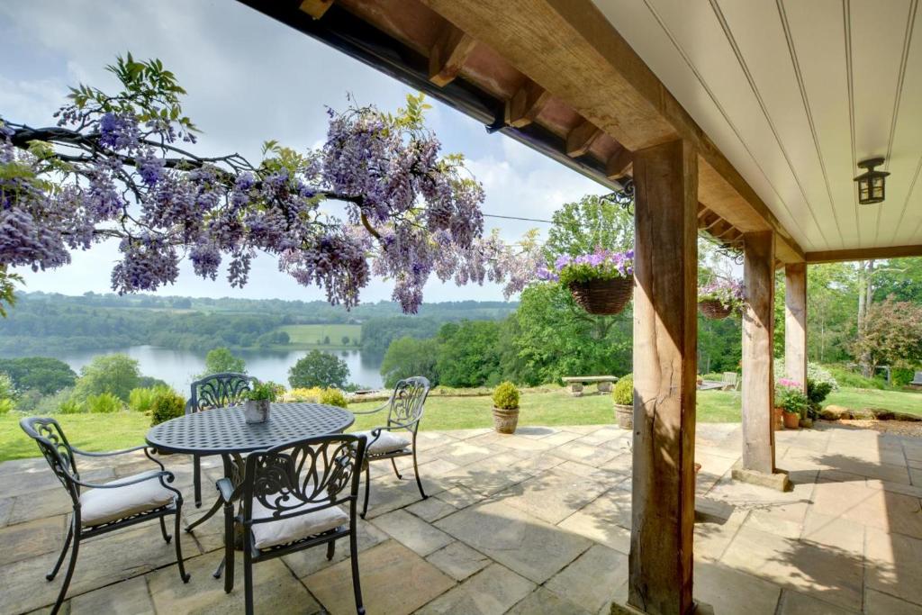 a patio with a table and chairs and a view of a lake at 1 Bed in Wadhurst oc-tw668 in Ticehurst