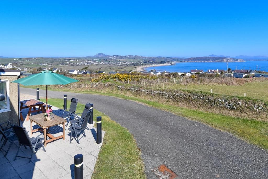 a patio with a table and chairs and an umbrella at 4 Bed in Bwlchtocyn oc-uchaf in Abersoch
