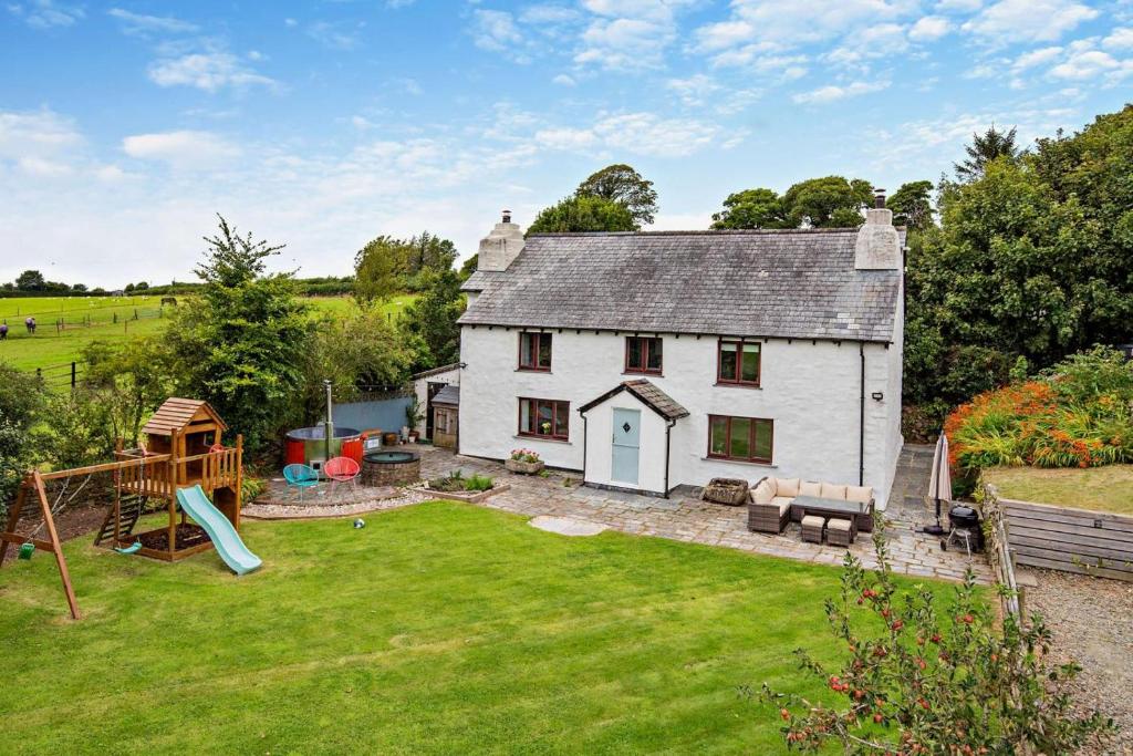 a white house with a playground in the yard at 5 Bed in Bodmin oc-l29658 in Blisland