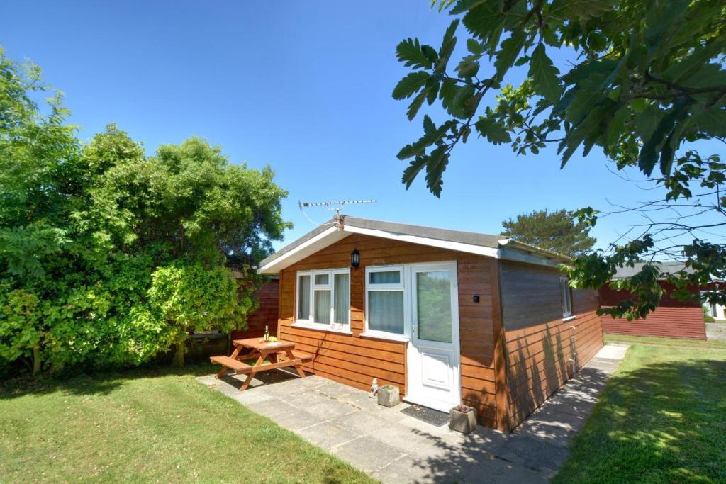 a tiny house with a picnic table in a yard at 2 Bed in St. Merryn oc-p00673 in Saint Merryn