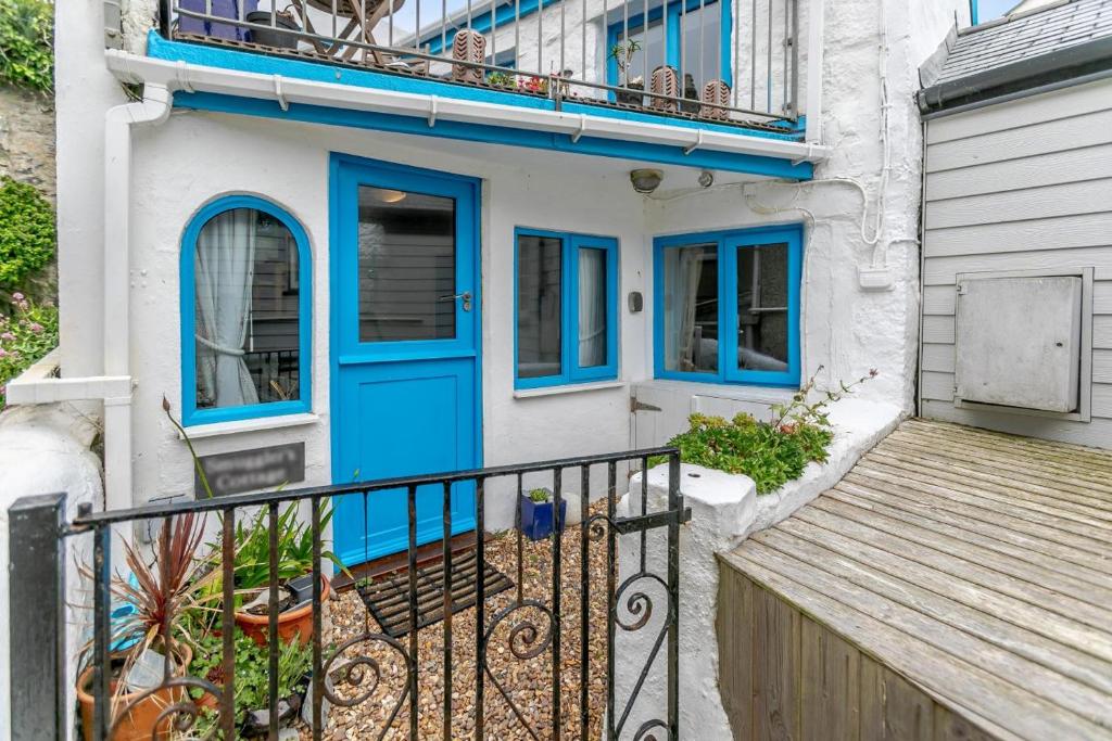 a house with a blue door and a balcony at 1 Bed in Porthleven oc-smuggl in Porthleven