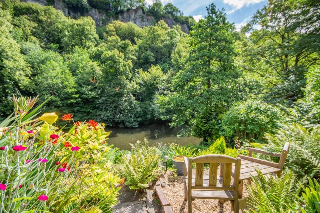 a garden with a bench and flowers and a river at 4 Bed in Matlock Bath oc-r32432 in Matlock Bank