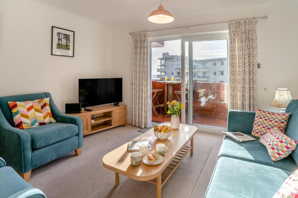 a living room with two blue chairs and a tv at 2 Bed in Langland oc-f30206 in Newton
