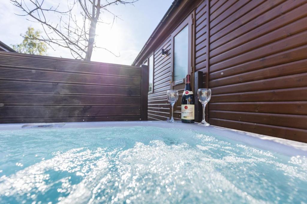 a hot tub with two glasses of wine next to a house at 2 Bed in Felton oc-w30642 in Felton