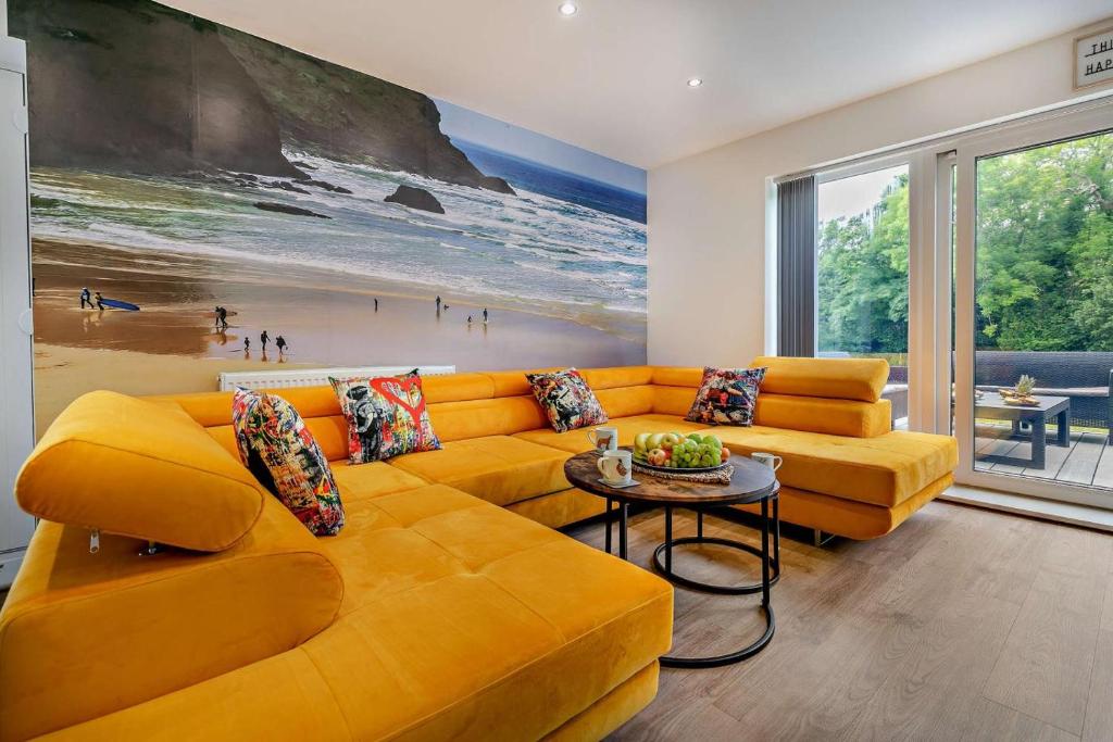 a living room with an orange couch and a painting at 4 Bed in Retorrick Mill oc-w28897 in Saint Mawgan
