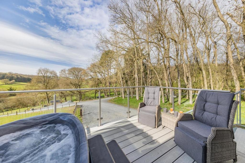 a deck with two chairs and a hot tub at 1 Bed in Berriew oc-a31113 in Berriew