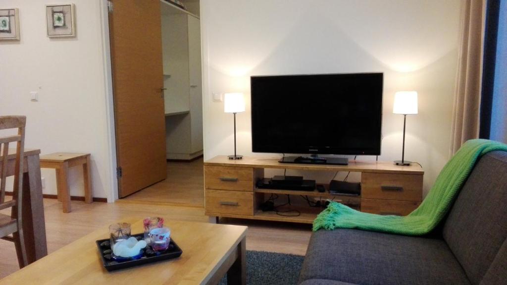 Apartment Ylläs Ski Chalets 8106, 2 Hissilippua talvella في يلاسشارفيه: غرفة معيشة مع تلفزيون بشاشة مسطحة على طاولة