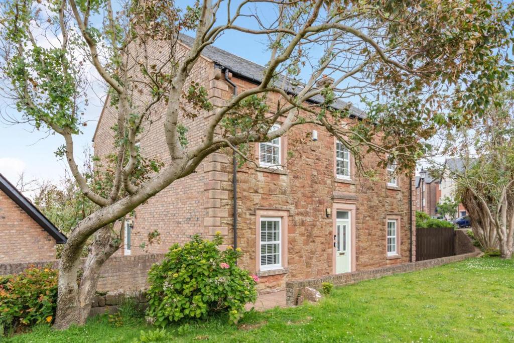 an old brick house with a tree in the yard at 5 Bed in St. Bees oc-w32446 in St Bees