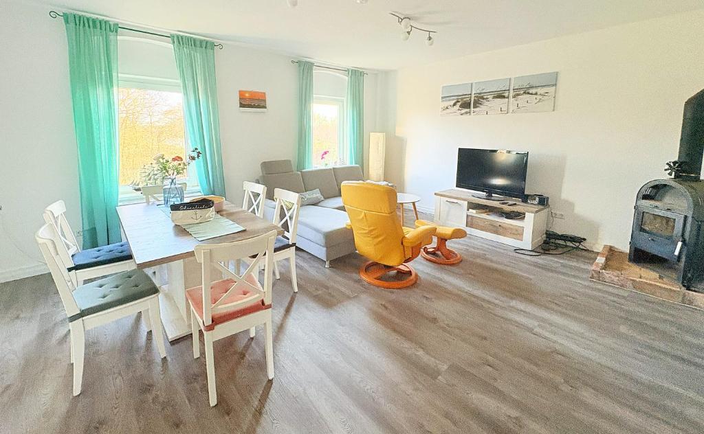 a living room with a table and a living room with a fireplace at Haus Waldblick - Natur pur am Rande des Nationalparks Jasmund in Sassnitz